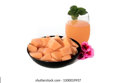 A Black Bowl Of Cubed Cantaloupe Melon With A Melon Cocktail  Isolated On White