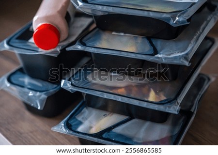 Black boxes with healthy diet plan for weight loss, delivery of daily ready meal menu. Food ordered with mobile phone app. Balanced portion with dish. Pre-cooking. High quality photo