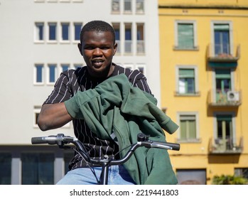 A Black Boy From Africa Puts On A Green Sweatshirt On Top Of His Bike. Urban Styling