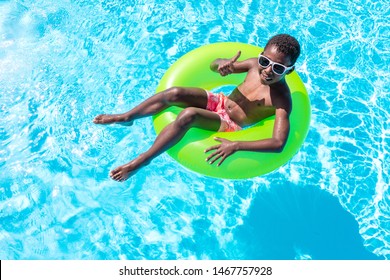 Black Boy In The Blue Water Pool On A Sunny Day