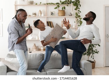 Black Boy, His Dad And Grandfather Having Fun At Home, Dancing And Singing In Living Room, Enjoying Spending Time Together