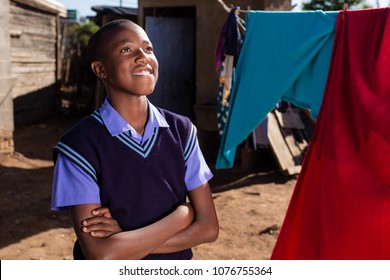 Black Boy Looking Away With A Smile On His Facewhile In A Township.