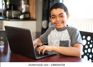 Black Boy Sitting Playing On A Laptop Computer At Home