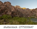 Black Bridge Clings To The Cliffs While Spanning The Colorado River In Grand Canyon National Park