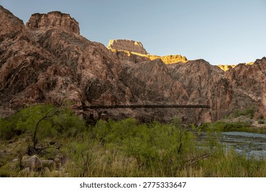 Black Bridge Clings To The Cliffs While Spanning The Colorado River In Grand Canyon National Park