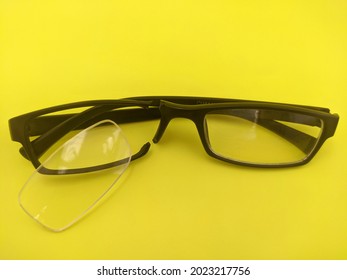 Black Broken Reading Glasses On A Yellow Background