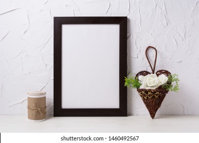 Black Brown  Frame Mockup With White Roses In The Wicker Heart Flower Pot. Empty Frame Mock Up For Presentation Design. Template Framing For Modern Art.