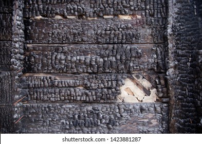 Black Burnt Wall Of House Of Wooden Planks With Embossed Texture. Damage To The Building From Fire Without The Possibility Of Restoration. Property Insurance.