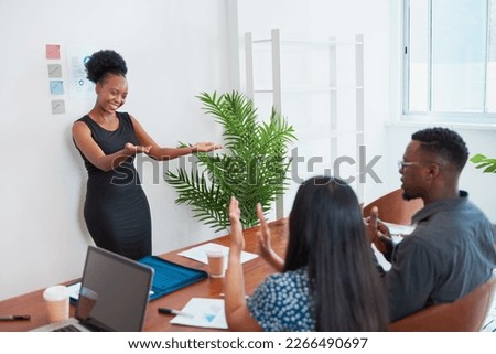 Black business woman thanks attendees at the end of presentation clapping