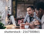 Black businessman and colleague talking in cafe