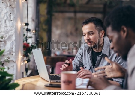 Black businessman and colleague talking in cafe