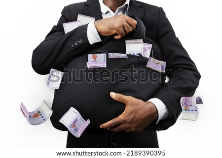 Black Businessman holding black bag full of 100 Malaysian ringgit notes isolated on white background, money falling from bag