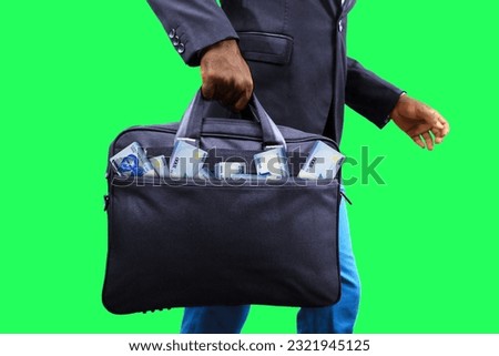 Black Businessman holding black bag full of stacks of Nigerian naira notes isolated on white background, money coming out of bag