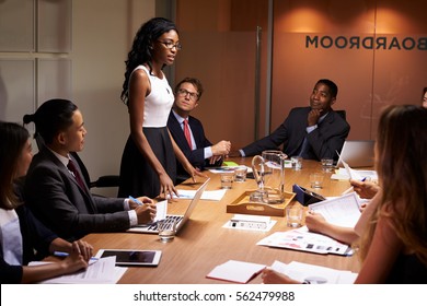 Black businesswoman stands addressing colleagues at meeting