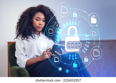 Black businesswoman using tablet, glowing lock hud hologram with hidden password. Online documents storage and protection. Concept of data security - Powered by Shutterstock