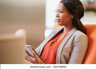 Black Businesswoman working on digital tablet in hotel lobby