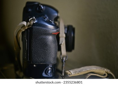 Black camera on dark background, India.