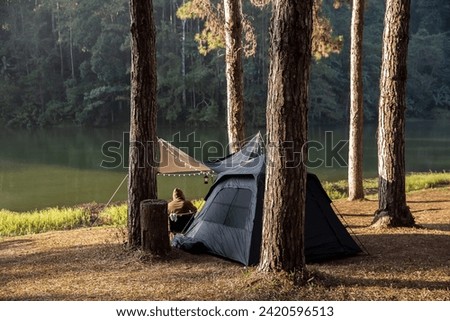Black camping tents in pine tree forest by the lake at Pang Oung Lake (Pang Tong reservoir) Mae hong son Thailand