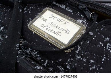 Black Canvas Zip Up Equipment Gear Bag In The Snow. Sideline Opening Equipment With Snow On It. Pull String. Zipper Bag. 