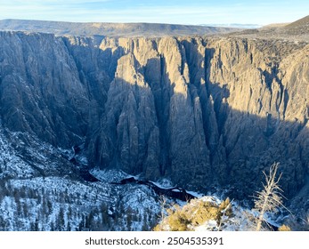 Black Canyon of the Gunnison National Park in Colorado. This winter scene showcases the steep, rugged cliffs blanketed in snow, offering a breathtaking and serene natural landscape. - Powered by Shutterstock