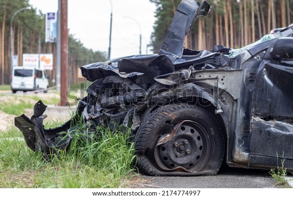 Black car\
after a terrible accident on the side of the road. Frontal and side\
impact. Life insurance. An accident without the possibility of\
recovery. Side view. Damage after an\
accident