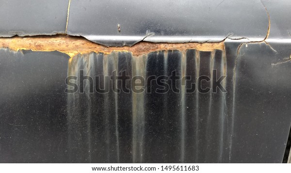The black car\
is cracked and has rust\
stains.