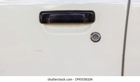 Black Car Door Handle Above The Key On A White Background.