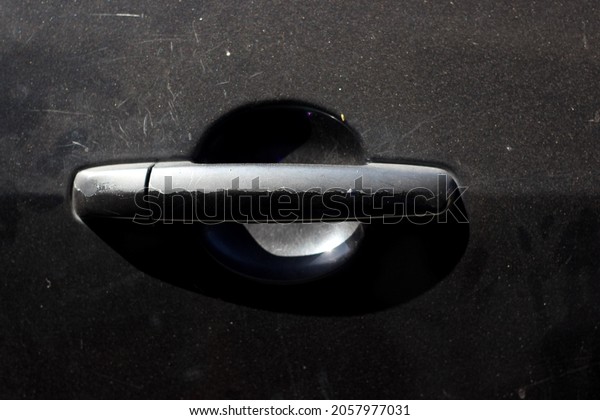 Black car door handle\
with peeling paint