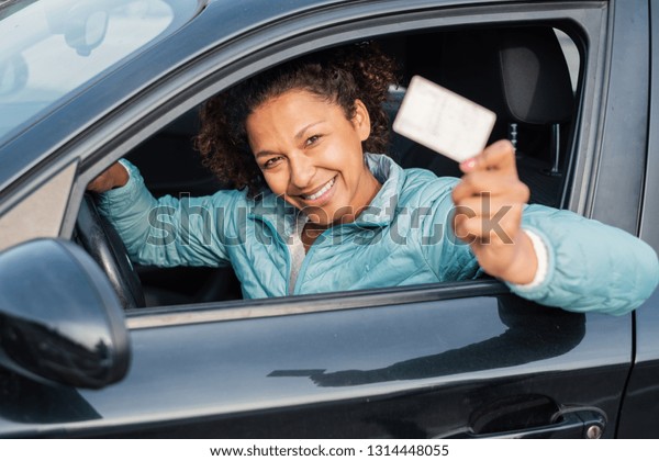 Black
car driver woman smiling showing driving
license