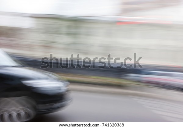 Black car in fast motion  with a deliberately\
blurred background in\
motion