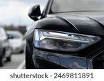 black car headlight, close up view, car dealing and manufacturing, cropped car image