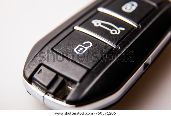 black car key with three buttons very\
close-up on a light\
background.