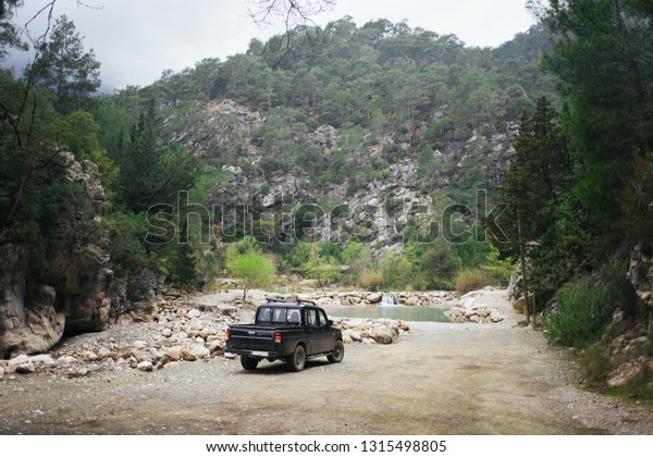 Black car on\
the background of mountains. A black pickup truck in the woods. A\
black pickup truck in the woods mountains in the background. SUV\
near the mountain\
river.\
