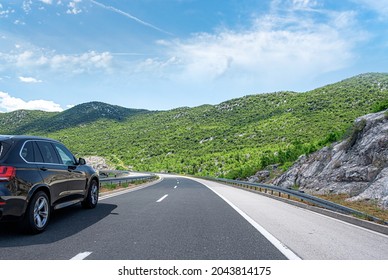 Black Car On A Scenic Road. Car On The Road Surrounded By A Magnificent Natural Landscape.