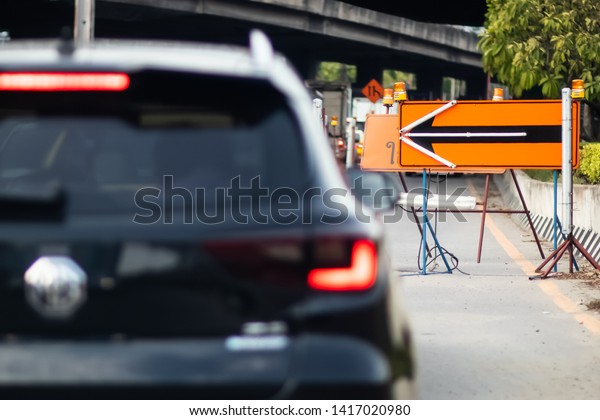 Black car and orange arrow sign\
pointing in different directions on the roads, Backgrounds\

