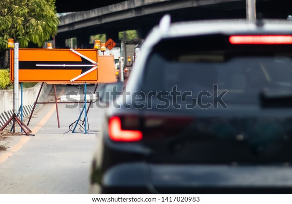 Black car and orange arrow sign\
pointing in different directions on the roads, Backgrounds\
