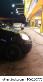 Black Car Park In Front Of Car Repair Shop, Change Tire, Blurred Image