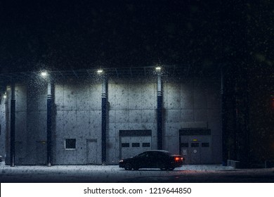 Black Car Parked Near Office Building In Winter Evening In Strong Snow Storm. Automobile Near Auto Service In Night. Machine Near Automatic Gate For Maintenance. Modern Architecture In Dark Night.