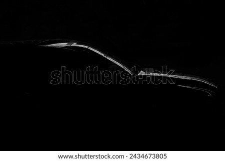 Black car standing at night parking. modern brandless cars. Transportation. Luxury car fleet consisting. neon light reflection on background. surface counter. Minimalist background with car silhouette