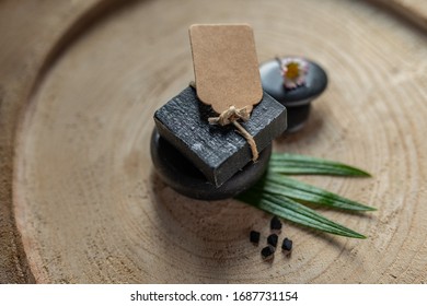 black carbon charcoal coal soap in a raw wood background 