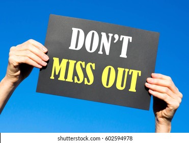 Black card placard with the concept of Don't Miss Out against a clear blue sky background