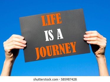 Black card placard with the concept of Life Is A Journey against a clear blue sky background - Shutterstock ID 585987428