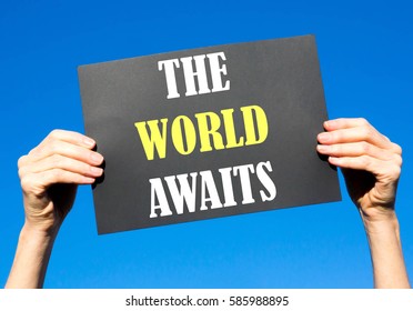 Black card placard with the concept of The World Awaits against a clear blue sky background - Shutterstock ID 585988895