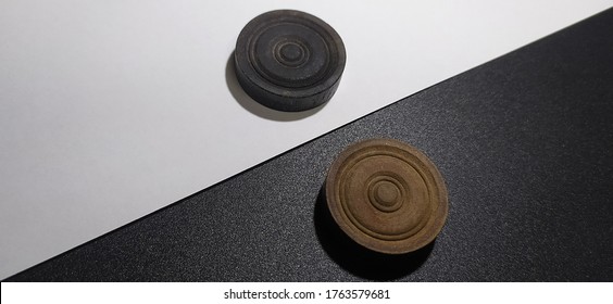 Black Carrom Coin On White Background And White Carrom Coin On Black Background. Symbolic Concept Of Color Or Racial Discrimination People Has To Suffer Because They Are From Different Places.