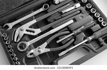 Black case with separated slots in shape of variety repairing hand tools angle view monochrome stock photo