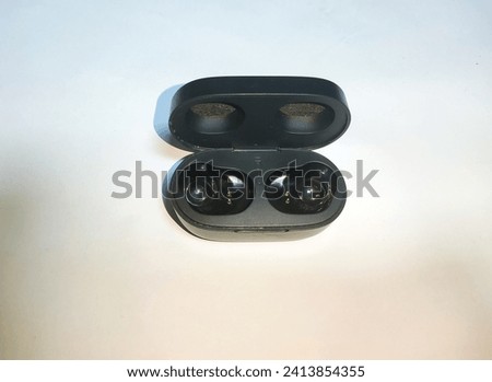 Black casing tws or true wireles earbuds. This object is used to charge a TWS that has run out of power