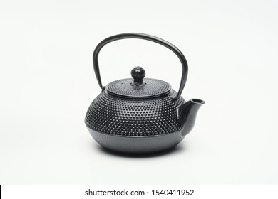 Black cast iron teapot on a white background. Asian culture.