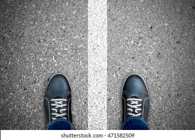 Black Casual Shoes Standing Over The White Line That Separate Left And Right. Standing On Both Side. Right And Wrong. Good And Bad.