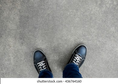 Black casual shoes standing and resting on asphalt concrete floor. Making decision what to do next