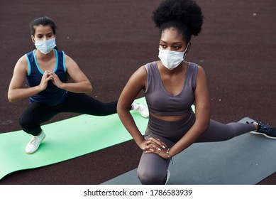 Black and Caucasian girls go in for sports outdoors in a protective mask. Prevention of coronavirus. Covid-19. Social distancing - Powered by Shutterstock